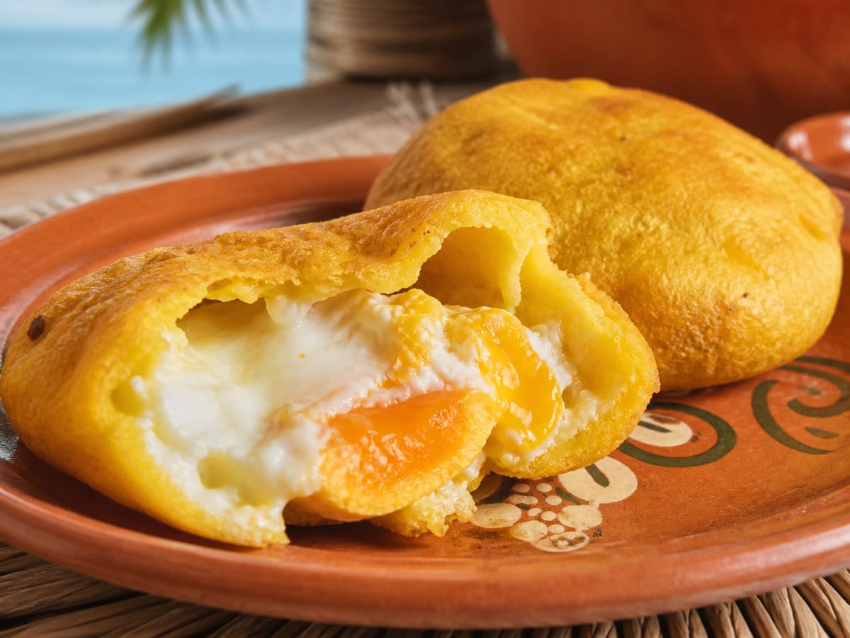 Arepa de huevo costeña abierta con el huevo visible en su interior